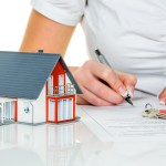 Frau unterschreibt Kaufvertrag für Haus